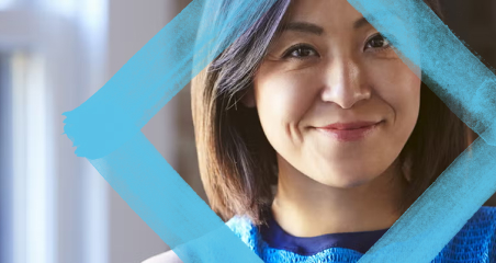 1. A woman with blue hair smiles brightly in front of a window, showcasing a cheerful expression and natural light.