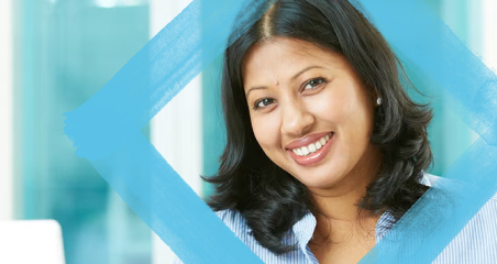 1. A woman smiling brightly against a solid blue background, conveying a sense of happiness and positivity.