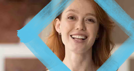 1. A woman smiles brightly in front of a blue-framed background, exuding joy and positivity.