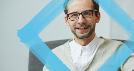 1. A smiling man wearing glasses with a blue frame, showcasing a friendly and approachable demeanor.