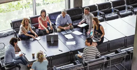 Business professionals collaborating in a meeting to develop essential strategic leadership skills.