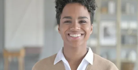 Girl smiling on camera while highlighting the flexible, student-centered online learning experience.